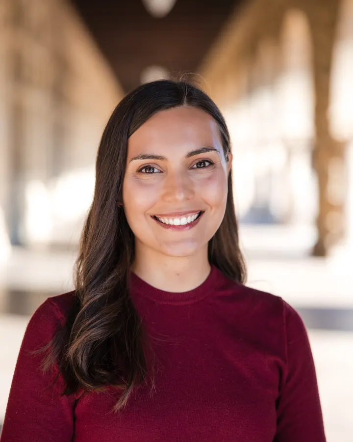Natural-light headshot under a stone arcade