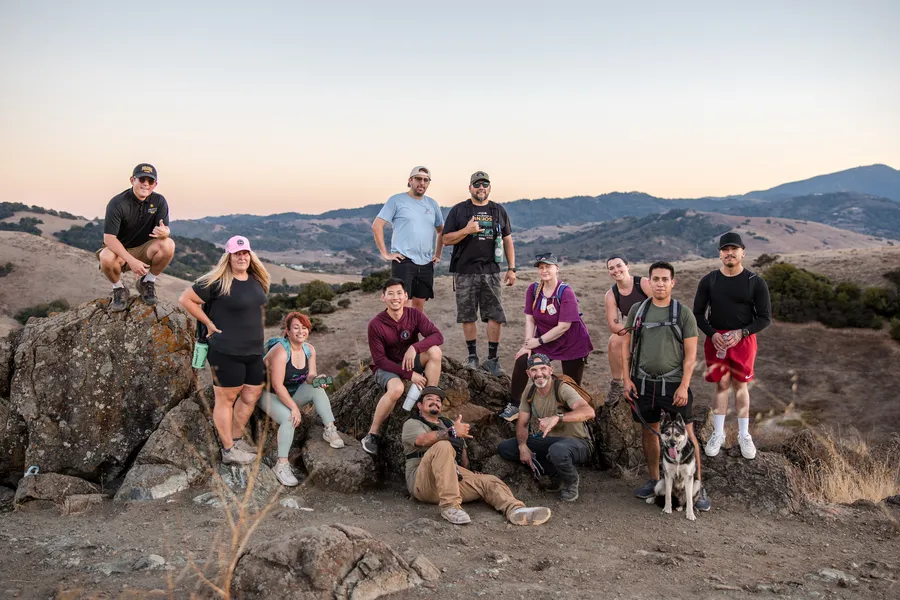 Hiking group celebrating on a ridgetop boulder