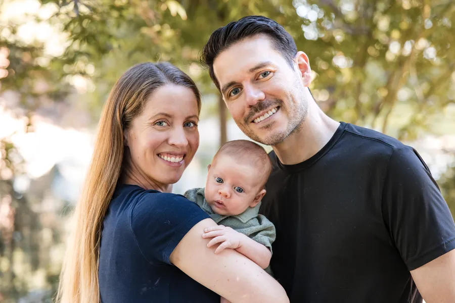 New parents with their baby under the willows
