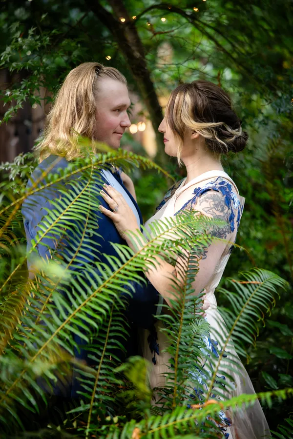 Couple framed by ferns, foreheads touching