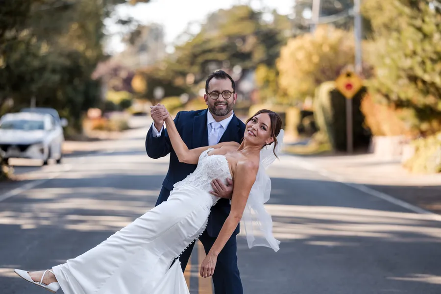 Groom dipping the bride under a cypress canopy