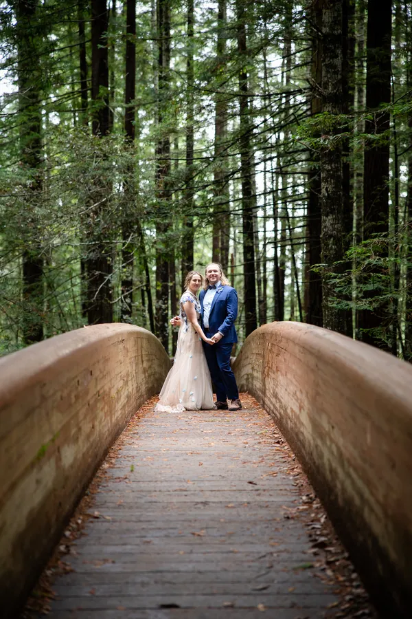 Couple on a wooden bridge among redwoods
