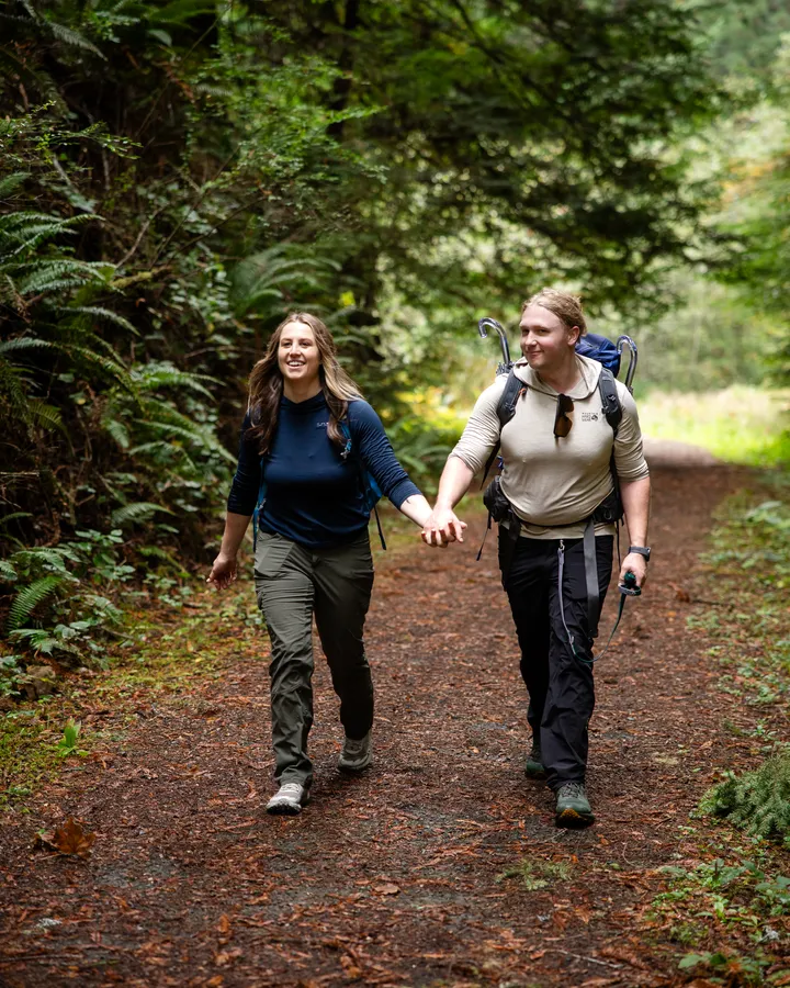 Couple hiking hand in hand through the forest